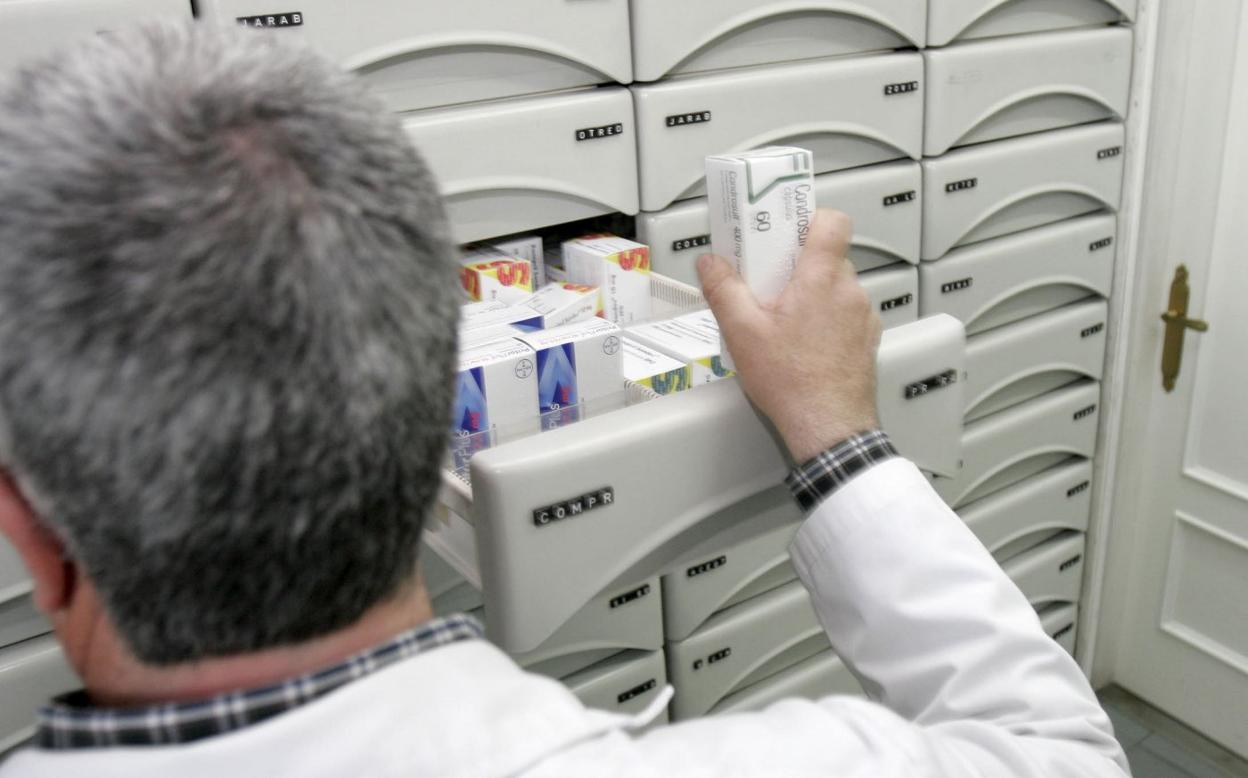 Un farmacéutico busca un medicamento para su venta. 