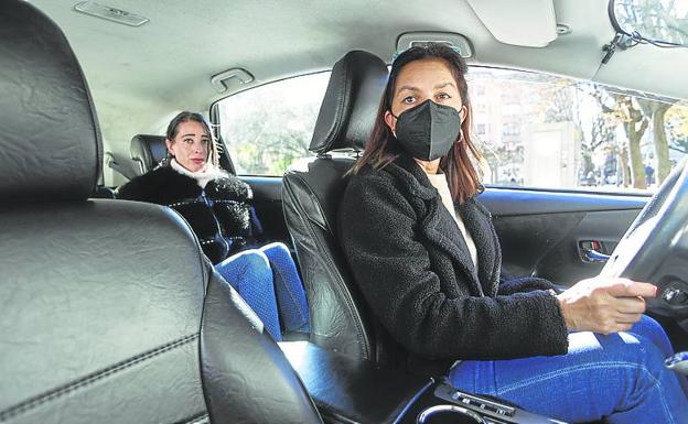 Una taxista con mascarilla y una pasajera sin ella, en Gijón. 