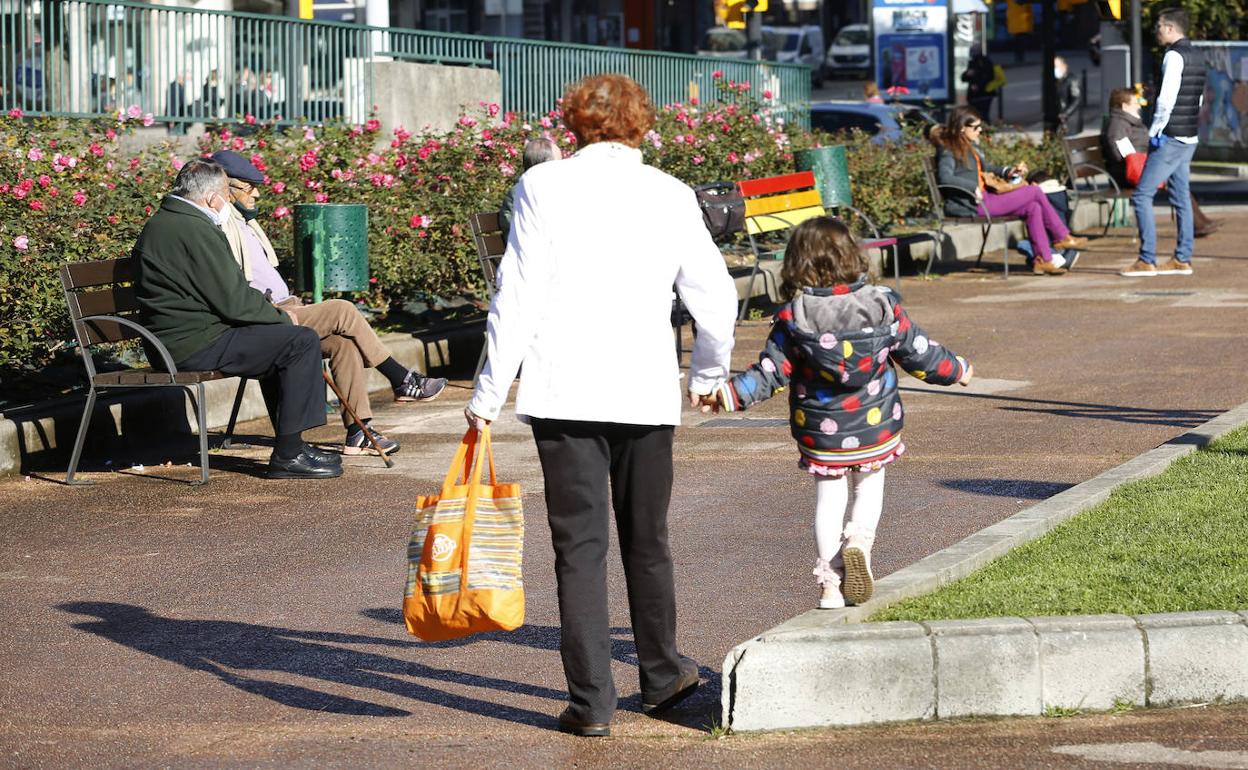 Una abuela pasea con su nieta por el parque de Cocheras, en Gijón. 