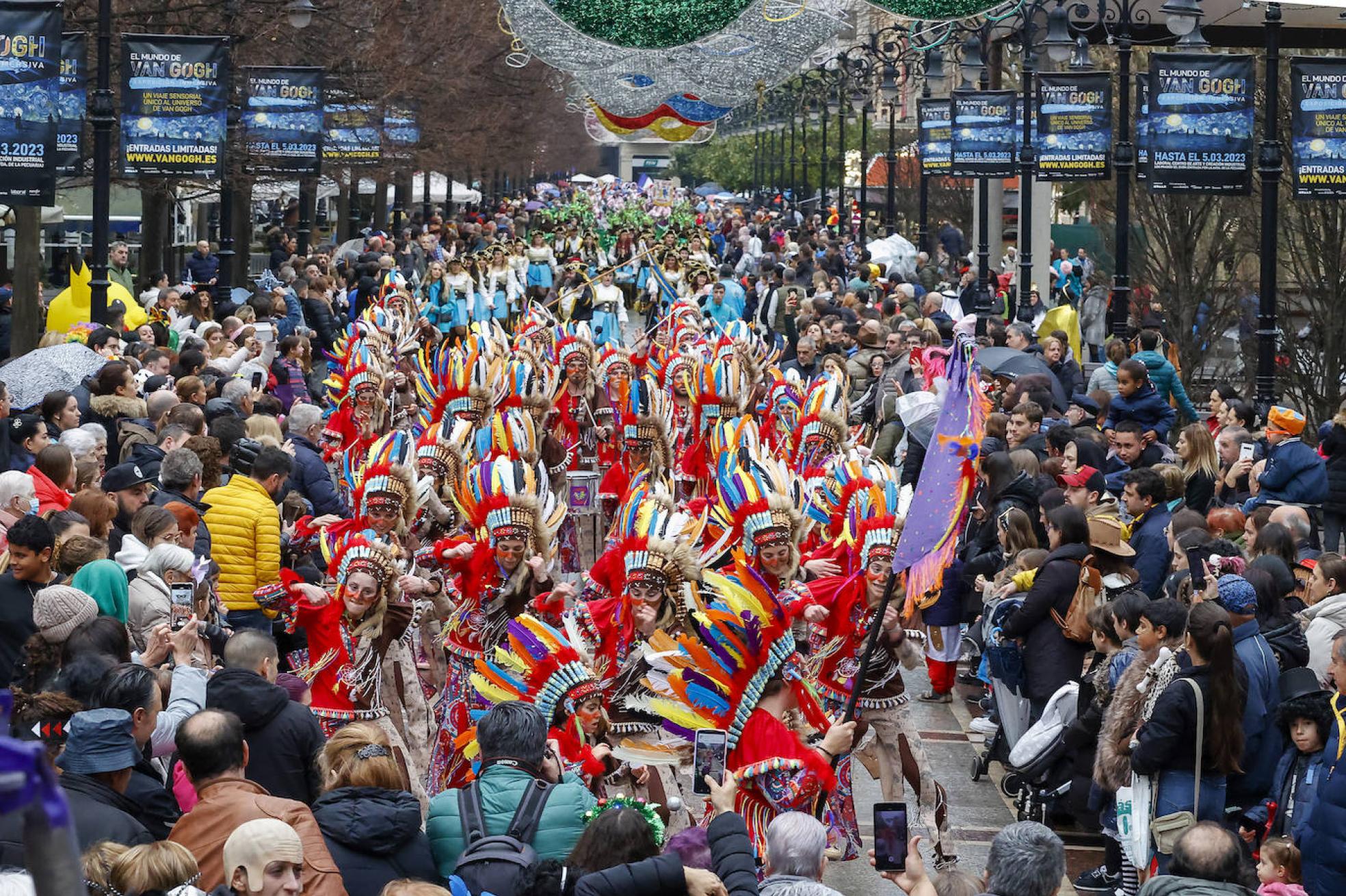 En primer término, Los Mazcaraos, ganadores del concurso de charangas, rodeados de una multitud en Begoña.