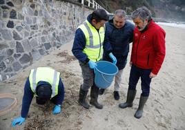 El consejero de Fomento, Alejandro Calvo, de rojo, con el alcalde de Muros del Nalón y dos componentes de las brigadas en la playa de Aguilar.