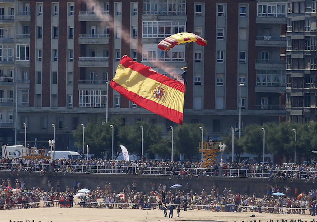 La bandera de España, en San Lorenzo, durante una exhibición de la Patrulla Acrobática de Paracaidismo del Ejército del Aire.