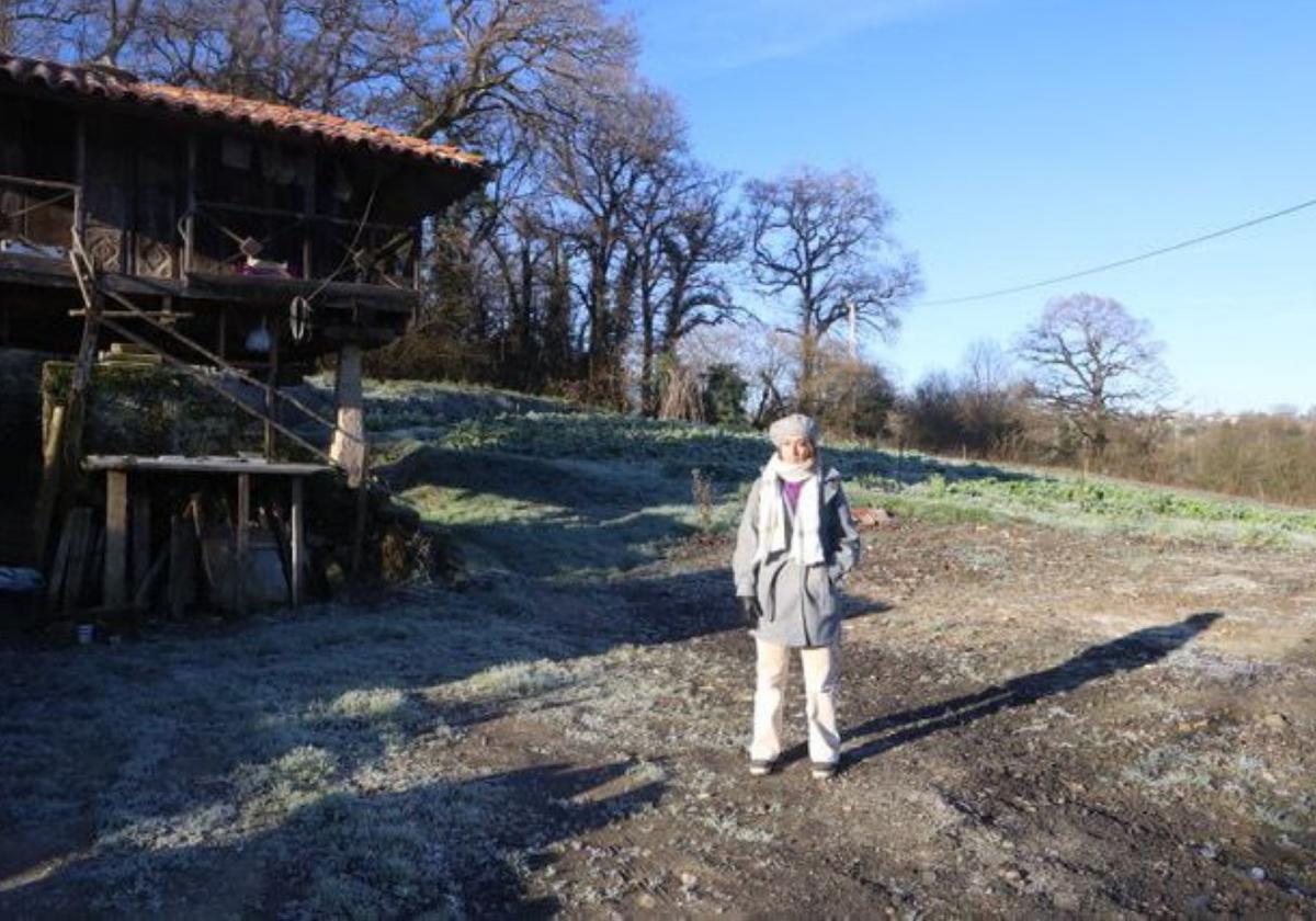 La concejala de Podemos en Siero Silvia Tárano muestra el lugar donde estaba la casa, con el hórreo aún en pie.