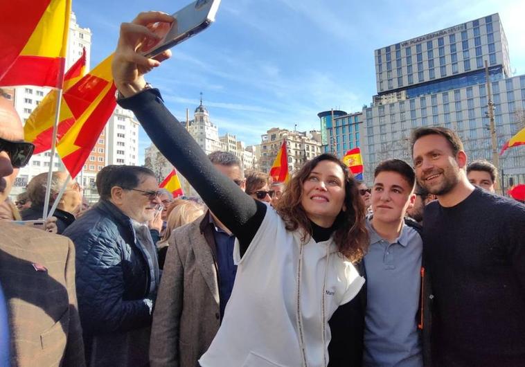 Isabel Díaz Ayuso y Álvaro Queipo se hacen un selfi junto a un seguidor del PP.