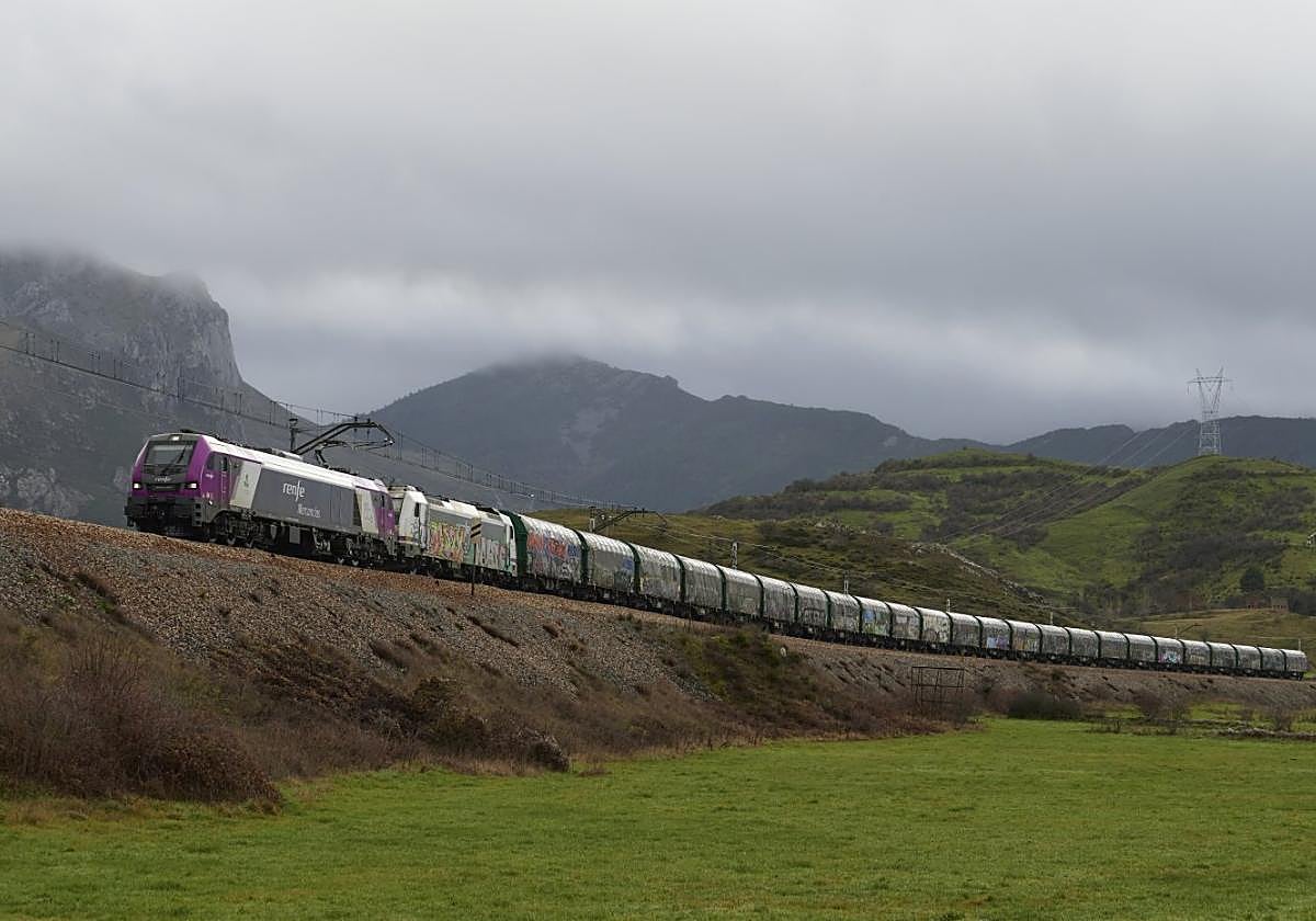 Locomotora E6000 fabricada por Stadler para Renfe, remolcando un convoy de mercancías por la rampa de Pajares.