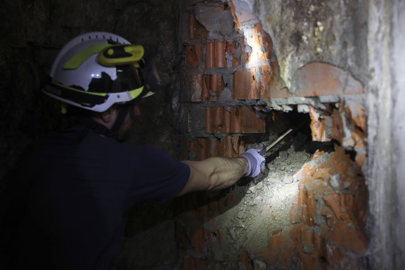 Uno de los bomberos descubriendo los escombros del acceso al pasadizo.