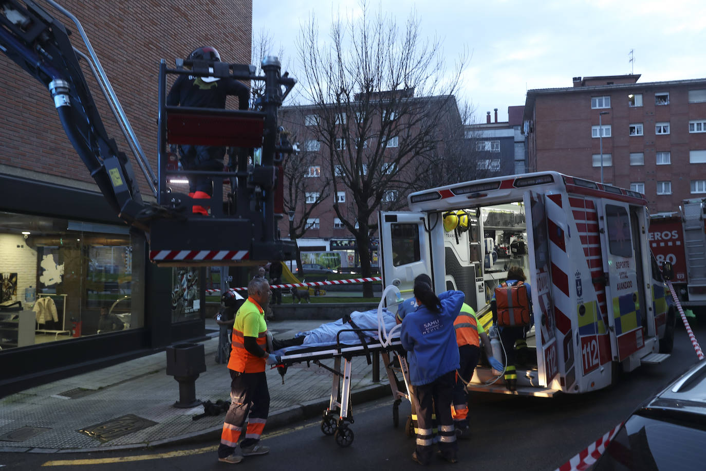 Maniobra de los bomberos de Gijón para sacar a una mujer inconsciente por la ventana