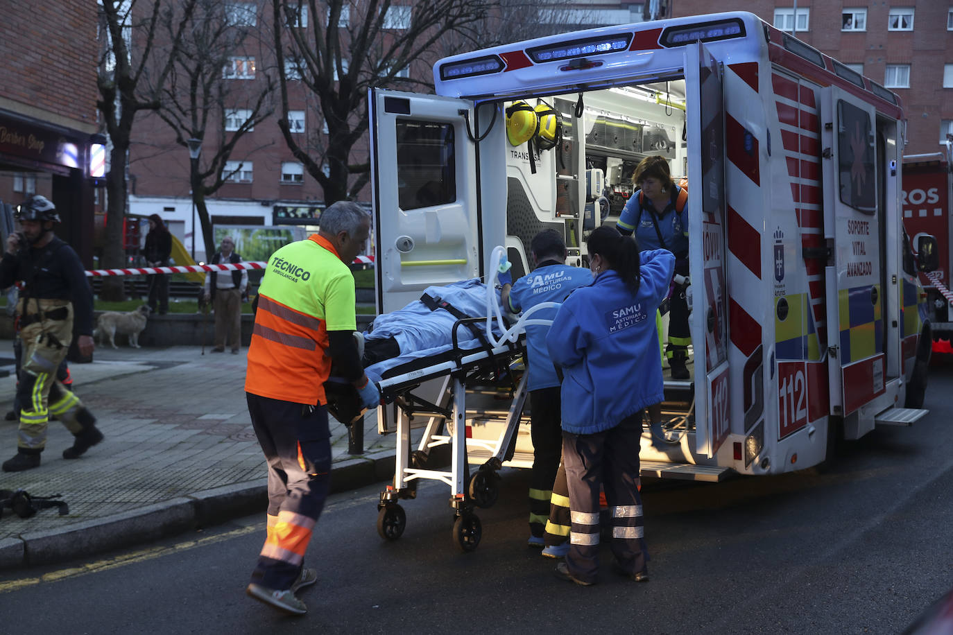 Maniobra de los bomberos de Gijón para sacar a una mujer inconsciente por la ventana