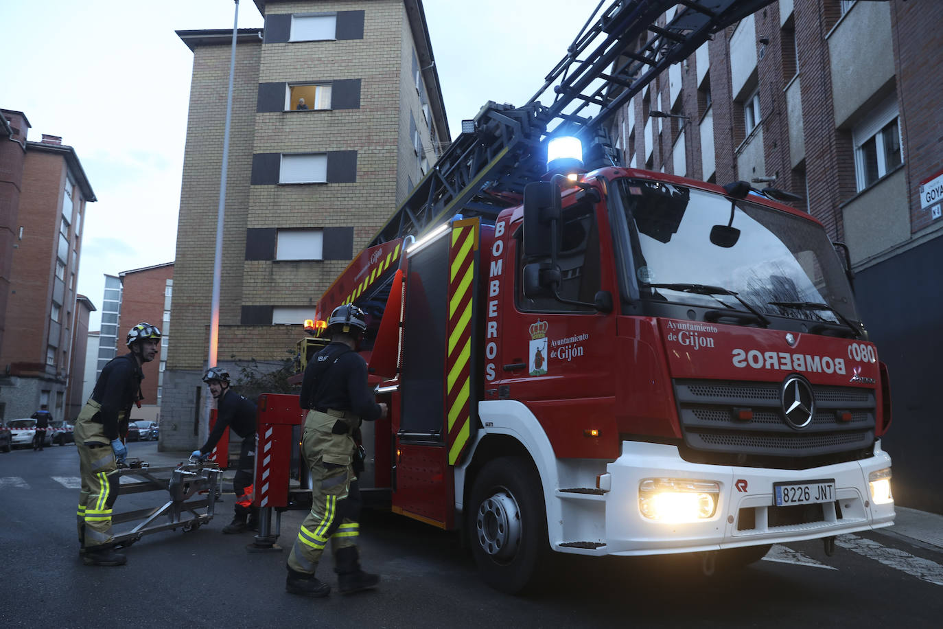 Maniobra de los bomberos de Gijón para sacar a una mujer inconsciente por la ventana