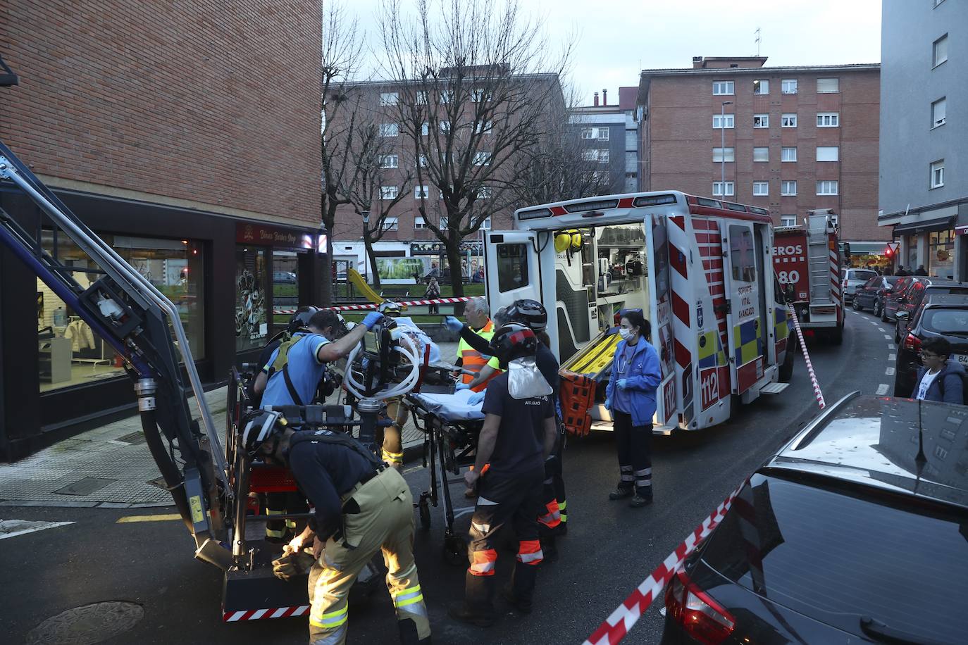 Maniobra de los bomberos de Gijón para sacar a una mujer inconsciente por la ventana