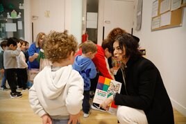 La edil de Cultura enseña a un niño uno de los libros.