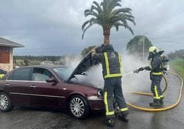 Dos bomberos trabajan en la extinción del fuego.