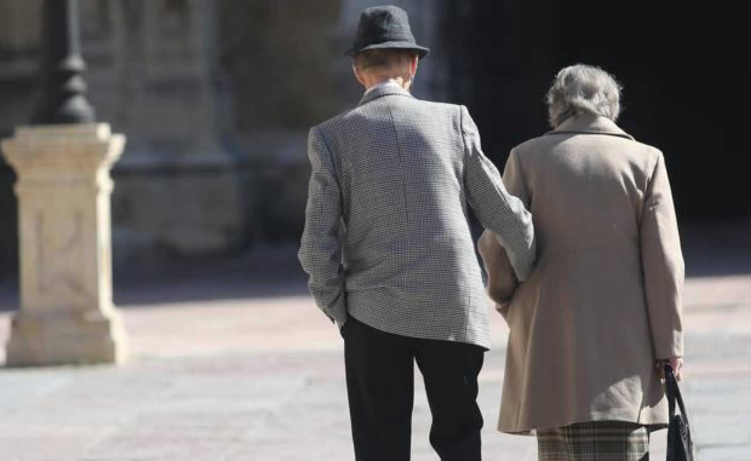 Una pareja de jubilados pasea por Oviedo.