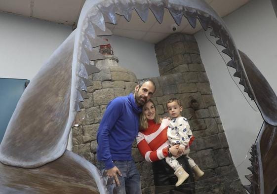 Una familia posa tras una de las piezas que conforma la exposición 'Tiburones'.