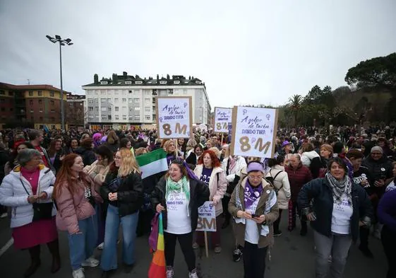 Participantes en la manifestación por el 8M en La Felguera donde se pueden ver algunos carteles en los que se puede ver el lema oficial 'A golpe de tacón. Dando tira'.