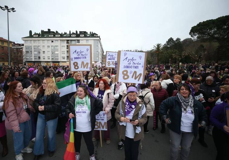 Participantes en la manifestación por el 8M en La Felguera donde se pueden ver algunos carteles en los que se puede ver el lema oficial 'A golpe de tacón. Dando tira'.