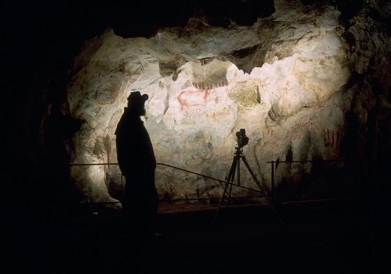 Un científico analizando las pinturas rupestres en la cueva de El Pindal, en Ribadedeva, hace unos años.