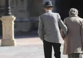 Una pareja de jubilados pasea por Oviedo.