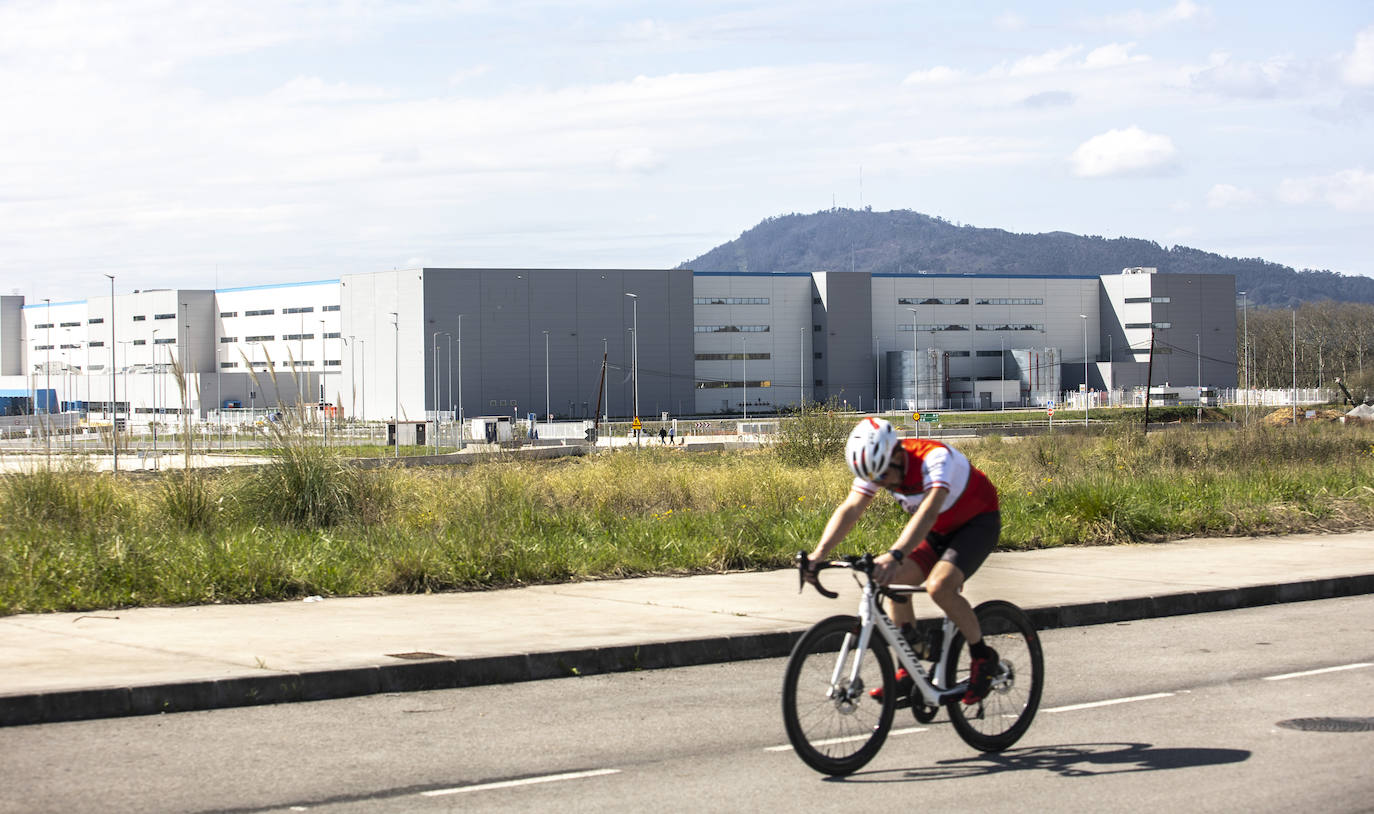 Un ciclista circula frente a la nave de Amazon en el polígono de Bobes.