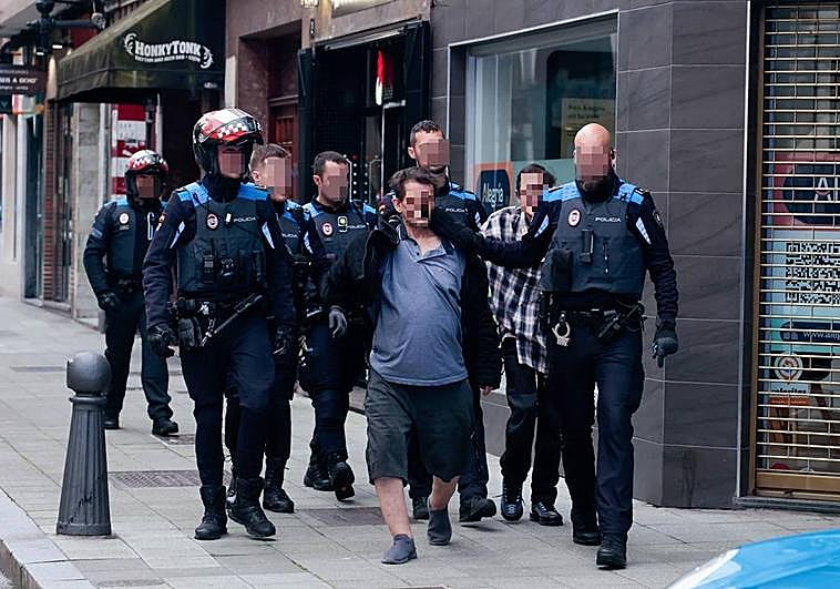 Foto: Los agentes, con los dos arrestados. Vídeo: El grito de auxilio del hombre encerrado en el 'narcopiso' de la calle Cabrales