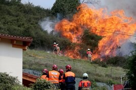 Bomberos y miembros de Protección Civil, durante las labores de extinción en la zona de Constante.