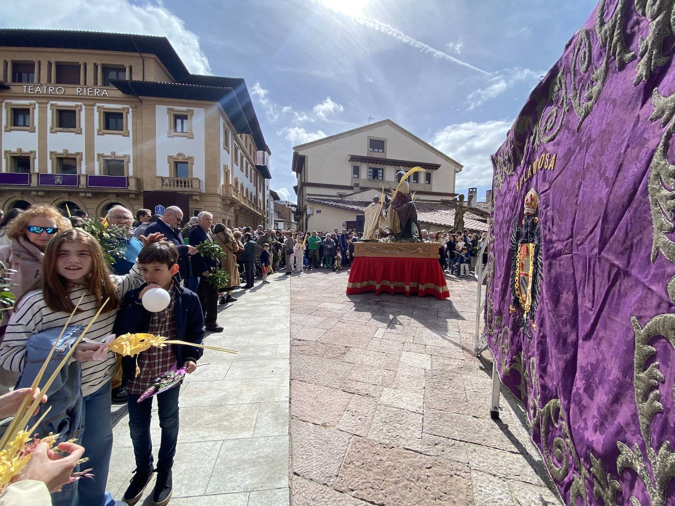 Cientos de personas rodearon la iglesia de Santa María de la Oliva de Villaviciosa y llenaron la plaza de Obdulio Fernández para recibir la bendición de sus ramos y palmas de la mano del párroco Gonzalo José Suárez. A continuación, sacaron el paso de La Borriquita en procesión al son del coro parroquial.