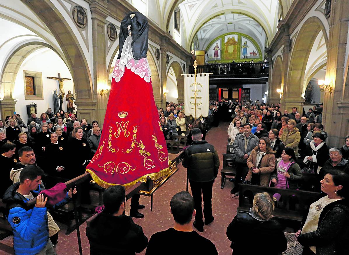 La imagen de la Virgen del Rosario, en la iglesia de Candás, rodeada de fieles.