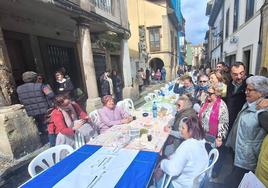 En la imagen, Adrián Barbón y Mariví Monteserín, junto a unas mujeres que disfrutan de la Comida en la Calle de Avilés en la calle Rivero. En el vídeo, el presidente del Principado habla con los medios.