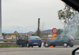 Los dos coches implicados en el accidente, uno de ellos envuelto en llamas.