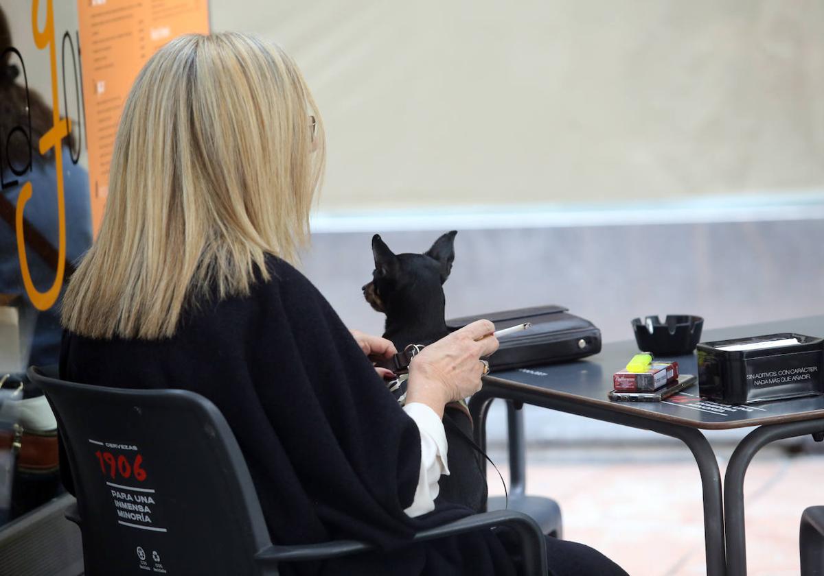 Una mujer fumando en una terraza en Oviedo.