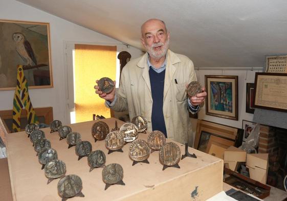 Juan Zaratiegui, en su taller, muestra la colección de medallas que ha donado.