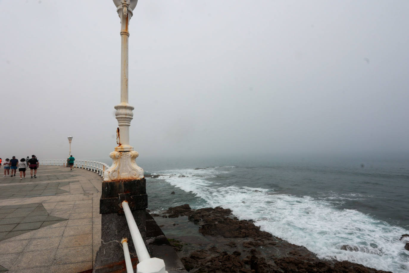 Gijón pasa de un día de sol y playa a una mañana siguiente de niebla