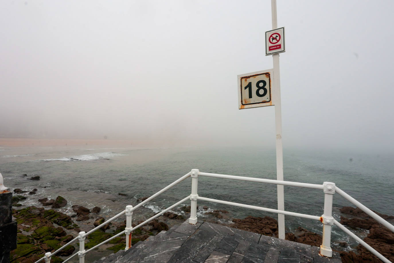 Gijón pasa de un día de sol y playa a una mañana siguiente de niebla