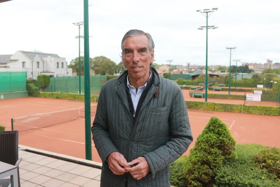 Tito Cueto-Felgueroso, presidente del Real Club de Tenis de Gijón, en la terraza de la cafetería de la entidad y al fondo dos de las pistas de tenis.
