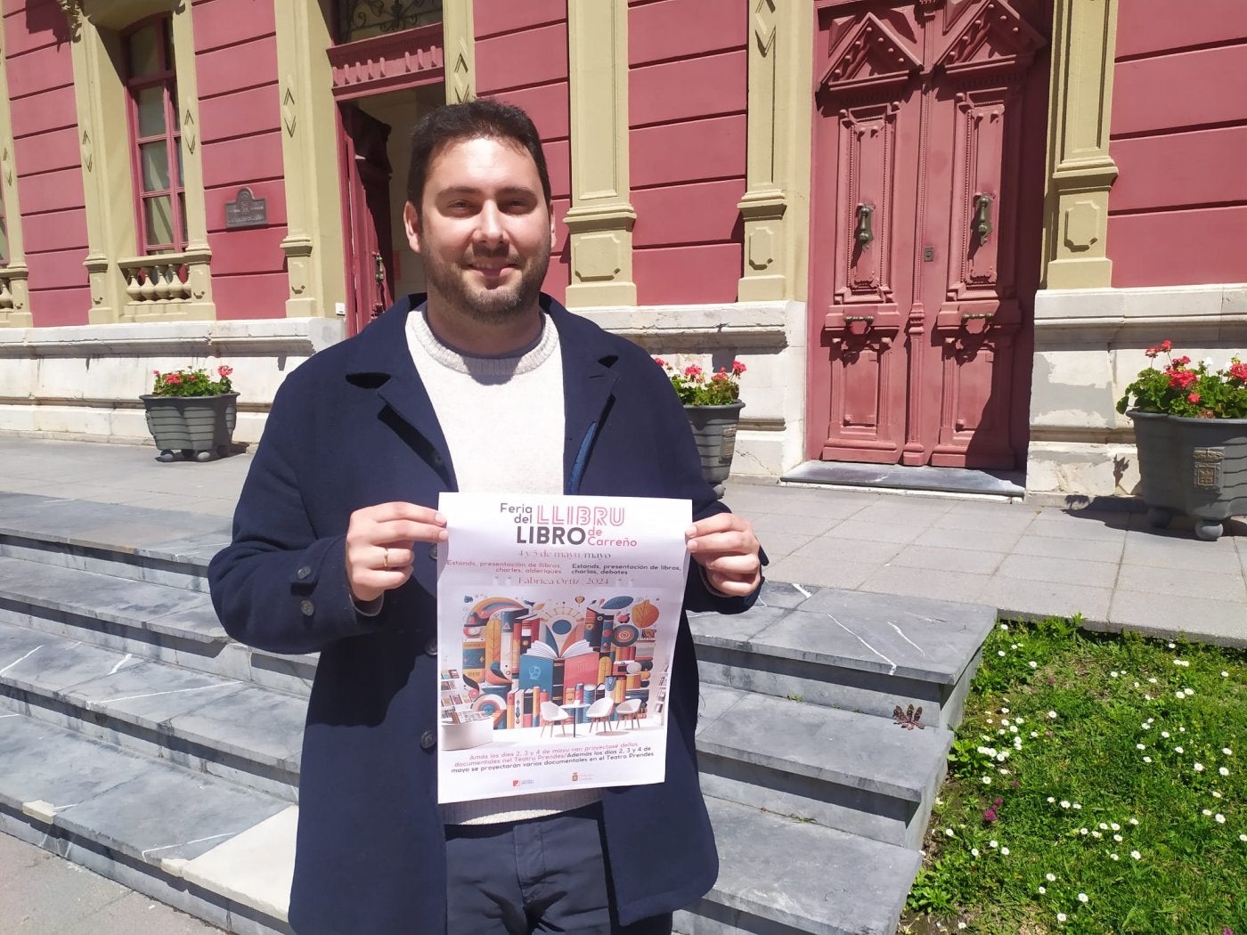 El edil de Cultura de Carreño, con el cartel de la feria del libro.