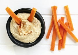 Hummus de garbanzos con palitos de zanahoria.