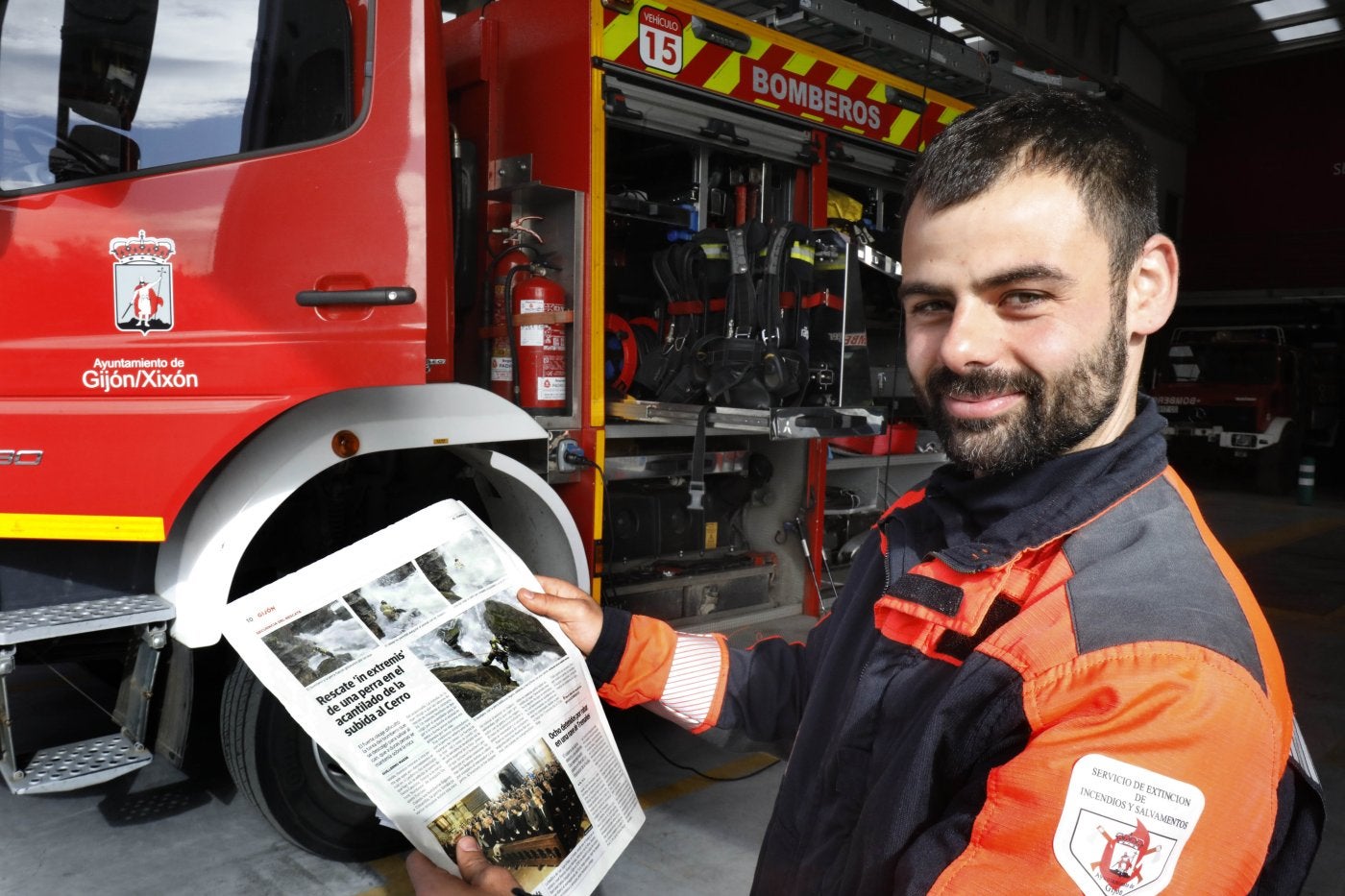 Alejandro Gallo, bombero que rescató a una perra en Cimavilla, posa con el reportaje de EL COMERCIO. JOSÉ SIMAL