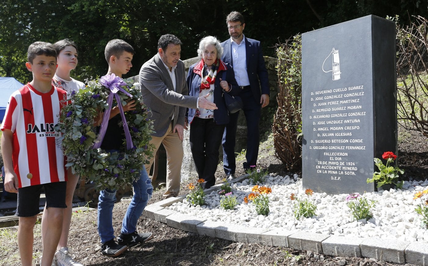 Los escolares Antonio García, Luz Álvarez y Olegario Díaz dejan la corona de flores en el memorial de La Sota, acompañados del alcalde de Laviana, Julio García, una familiar de una víctima, Maribel Morán, y el presidente de Hunosa, Enrique Fernández.