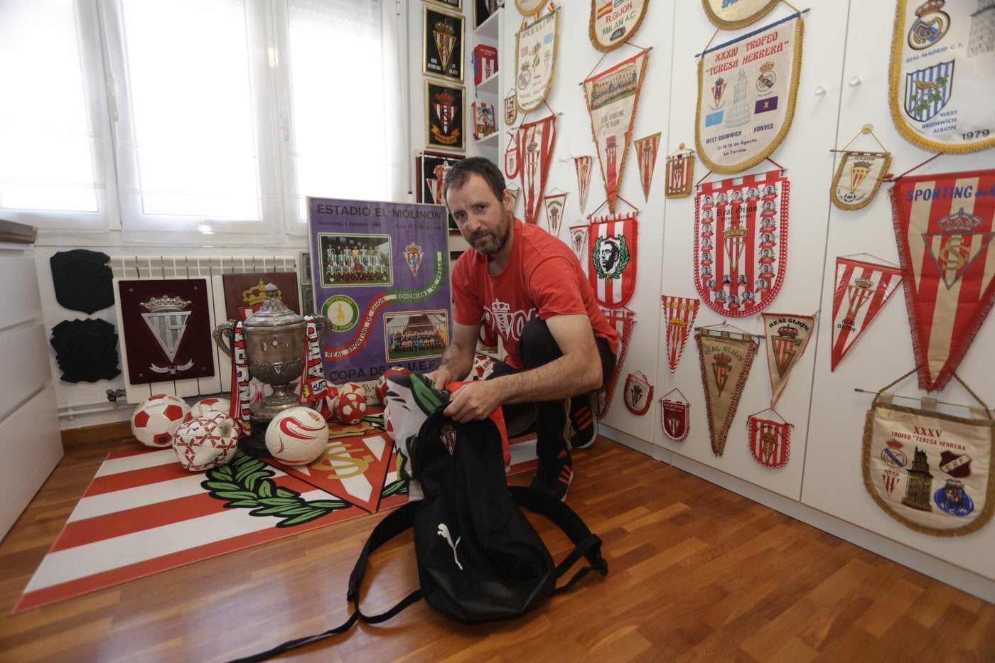 Milinko prepara la bandera con el rostro de Anselmo López que lleva en todos sus viajes.