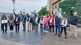Concejales y hosteleros escancian junto al árbol de la sidra tras presentar 'Gijón vive la sidra'.