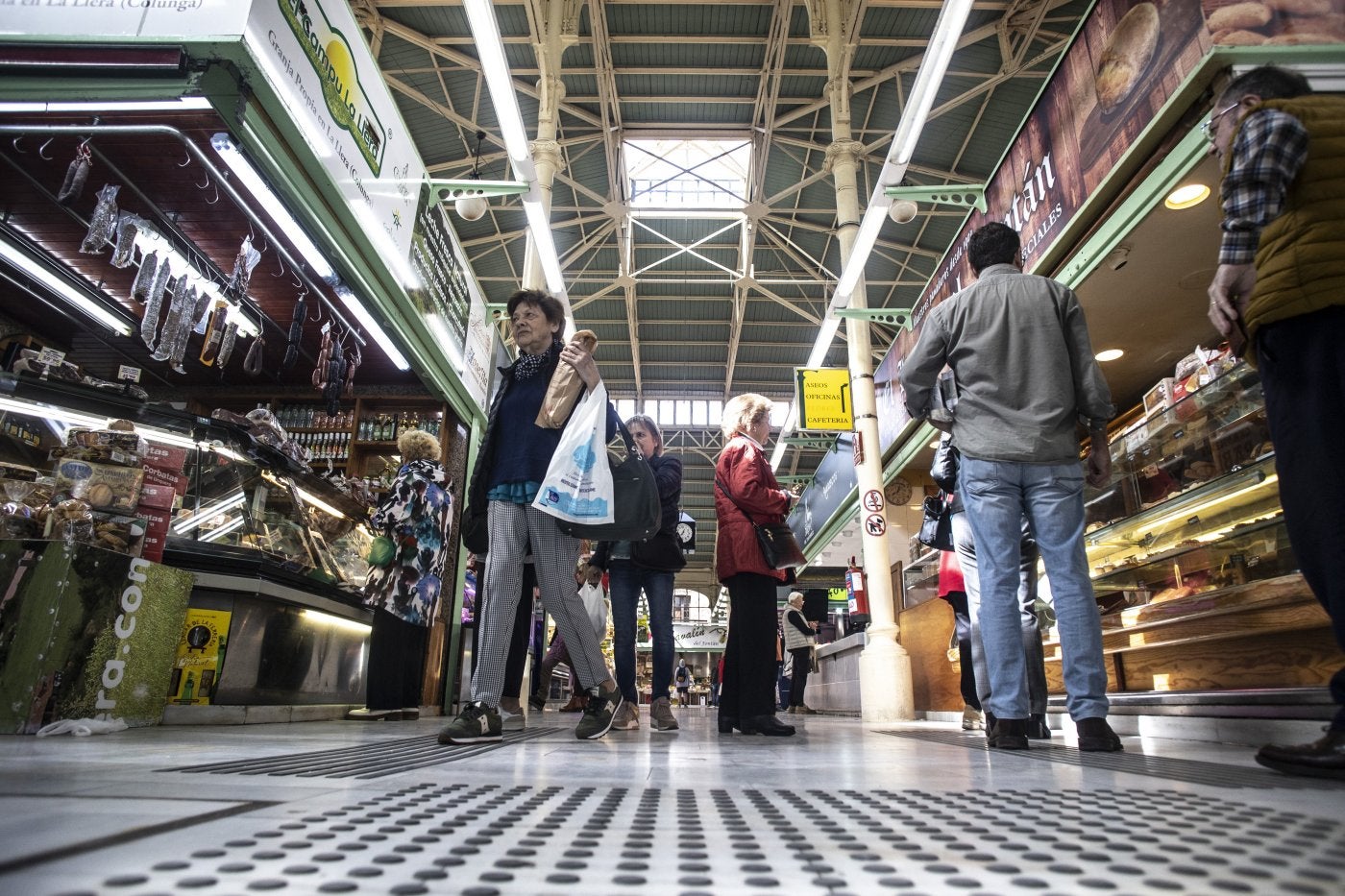 Clientes comprando en los puestos del mercado del Fontán.