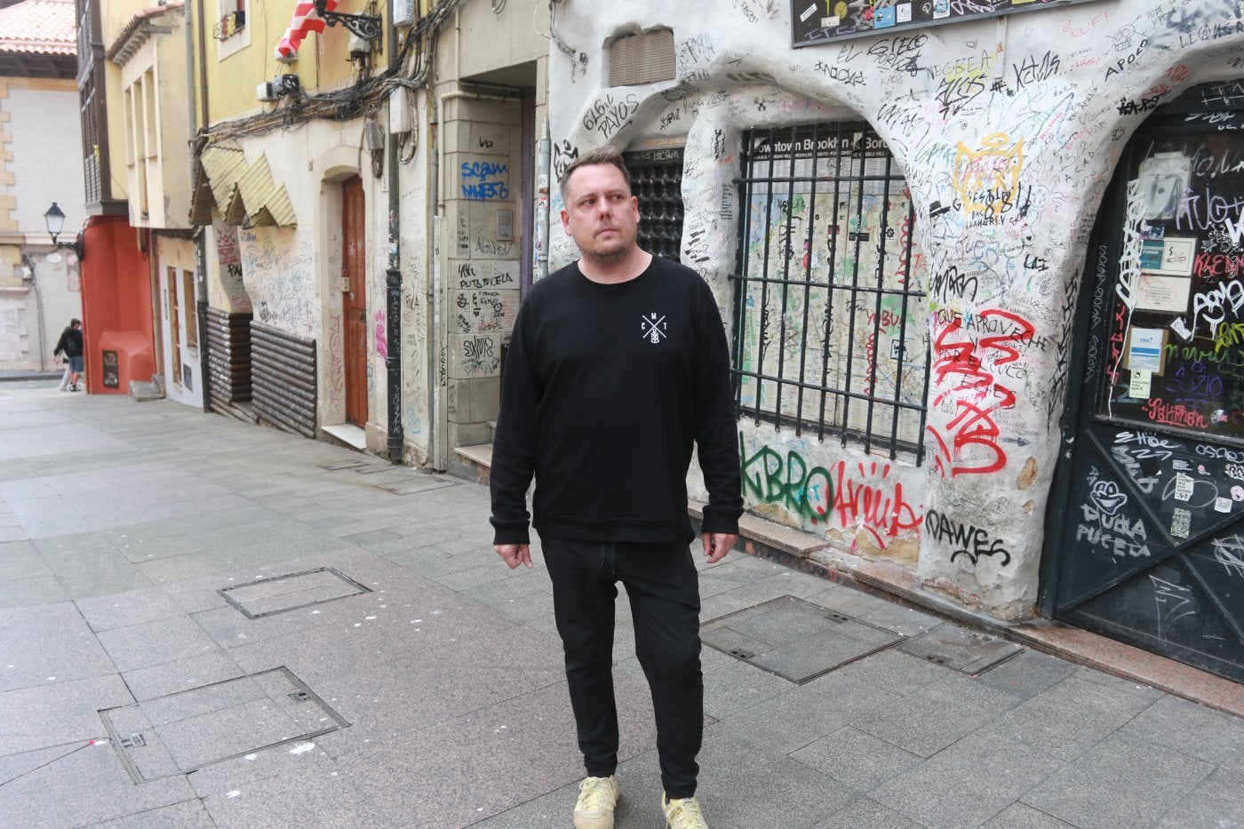 Sergio Álvarez, presidente de la asociación de vecinos, en la calle de la Vicaría, llena de pintadas.