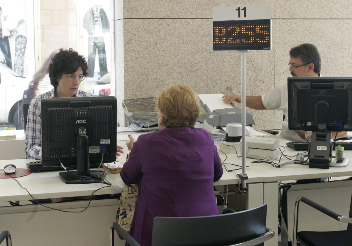 Una mujer hace una consulta en las oficinas del Instituto Nacional de la Seguridad Social de Gijón.