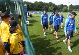 Dani Calvo y Borja Bastón pasan al lado de un grupo de jóvenes de Hong Kong de visita en El Requexón.