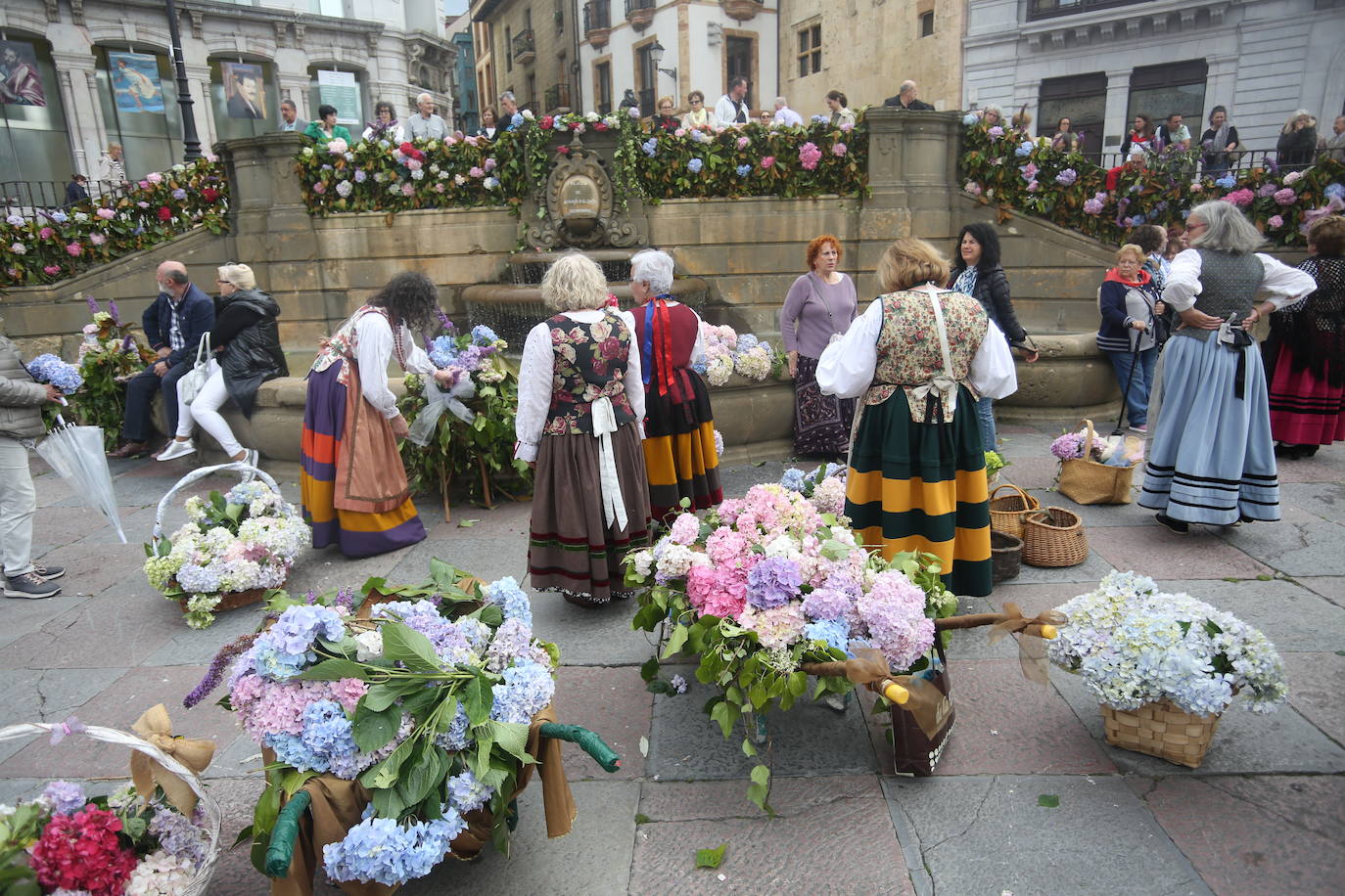 El Coru Muyeres de San Esteban enramó las fuentes del casco histórico de Oviedo