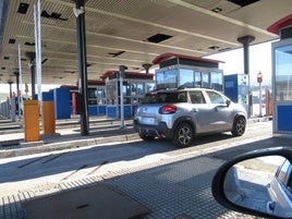 El conductor de un turismo se dispone a abonar el coste del peaje de la autopista del Huerna en las cabinas de La Magdalena.