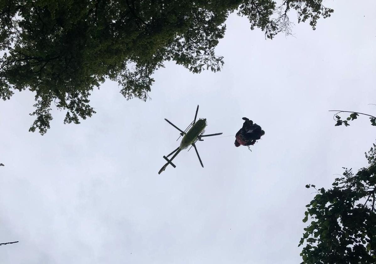 El helicóptero de los bomberos evacuando a la mujer.