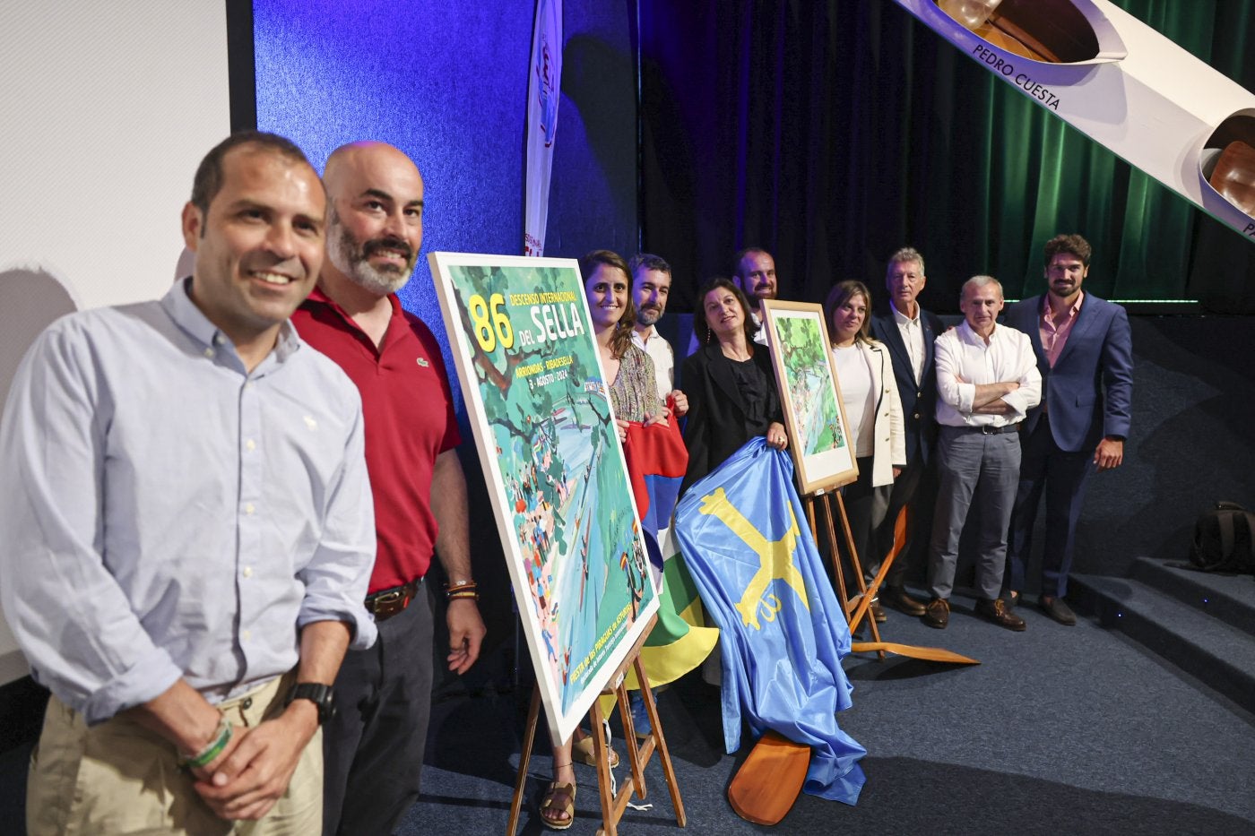 Organizadores y autoridades posan con el cartel de la 86 edición del Descenso Internacional del Sella.