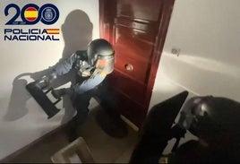 Momento en el que agentes de la Policía Nacional fuerzan la puerta de la casa donde se escondían los arrestados, así como el material robado.