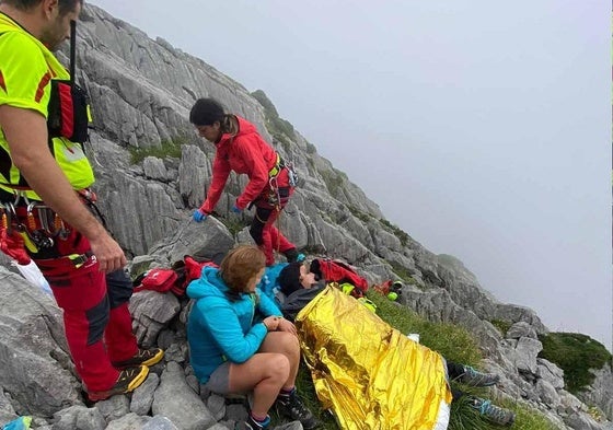 Los efectivos de rescate junto a la mujer herida y su acompañante.